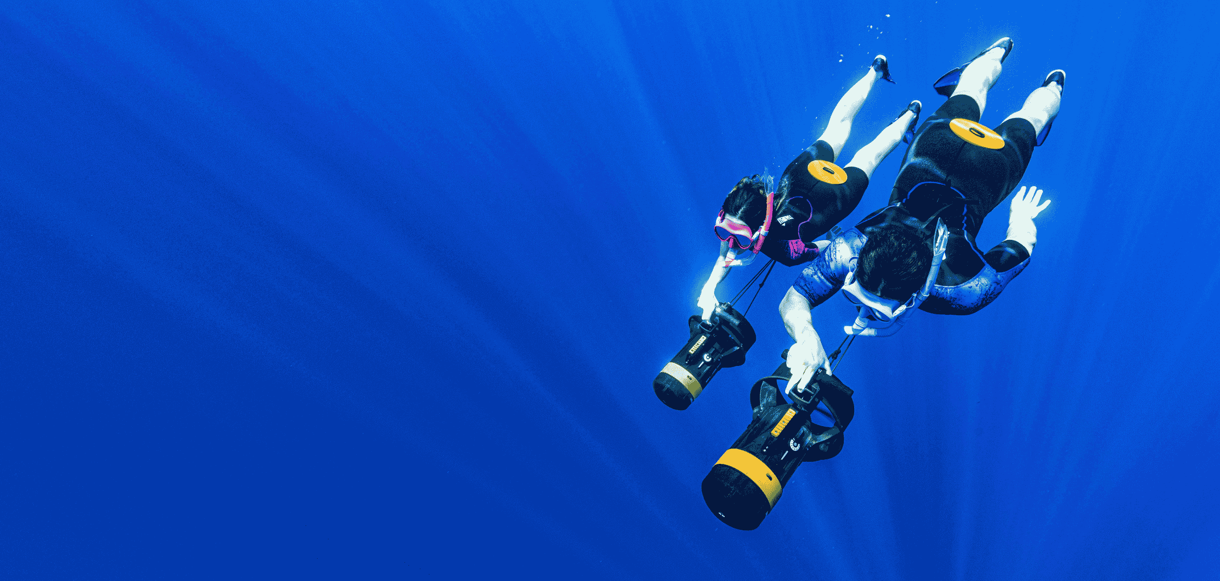 Two freedivers descending, towed by NEMO DPVs
