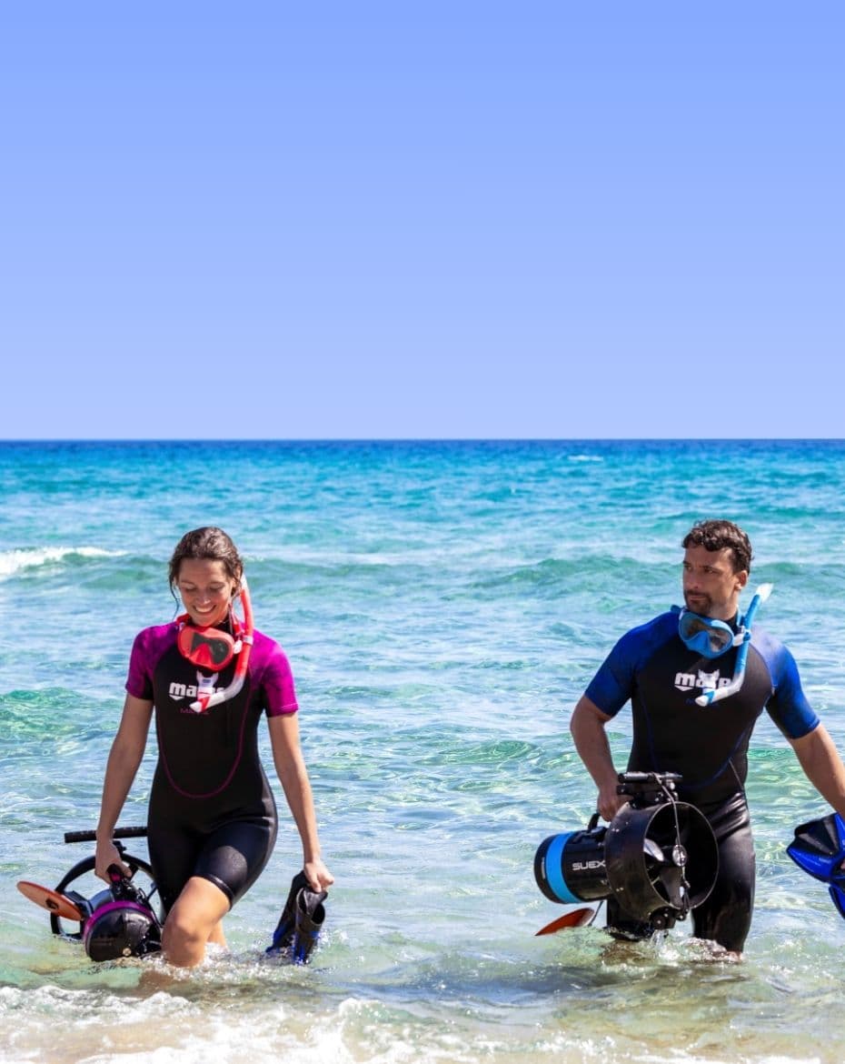 Two guests of a dive centre entering the water with NEMO DPVs