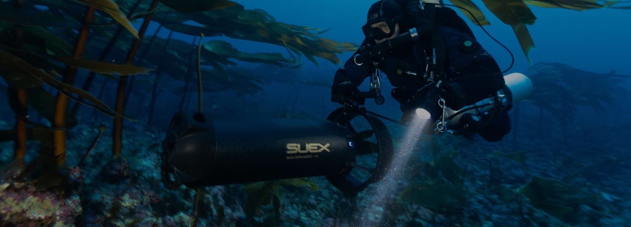 Taucher mit einem SUEX Goldfinder XJ DPV zwischen den Algen eines Kelpwalds